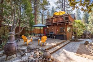 eine Hütte im Wald mit Stühlen und einem Sonnenschirm in der Unterkunft The Gingerbread Cottage in Kings Beach