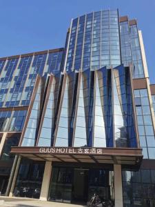 a tall glass building with a sign on it at Guus Hotel in Zengcheng