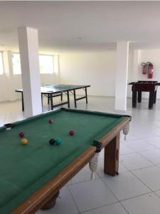 a pool table with balls on it in a room at apartamento em Jacumã in Jacumã