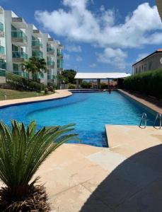 a large swimming pool in front of a building at apartamento em Jacumã in Jacumã
