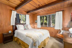 una camera da letto con letto in una camera in legno di The Honey Bear Cabin a Carnelian Bay