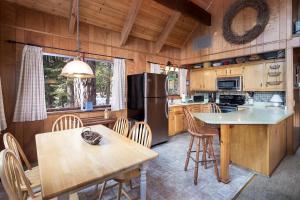 a kitchen with a table and a refrigerator at The Honey Bear Cabin in Carnelian Bay