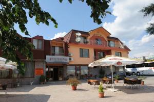 a building with an umbrella and tables and chairs at Complex Racic in Voyvodinovo