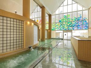 Jozankei的住宿－定山溪鶴雅休閒渡假溫泉飯店森之謌，大窗户的大房间里的一个水池