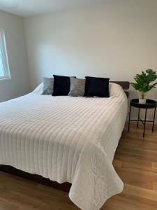 un dormitorio con una cama blanca con una planta en Bright Napa Home en Napa