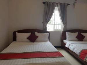 フーコックにあるThảo Nhớ Hotel PQ - by BAY LUXURYのベッド2台と窓のある寝室