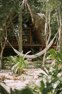 a tree house with a hammock in the woods at 7 CIELOS BACALAR. in Bacalar