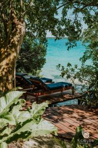 eine Gruppe von Liegen auf einer Holzterrasse in der Nähe des Ozeans in der Unterkunft 7 CIELOS BACALAR. in Bacalar