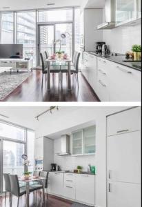 una cucina con armadi bianchi e tavolo con sedie di Downtown Toronto Luxury Condo a Toronto