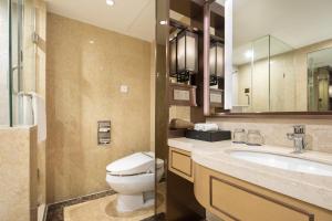 a bathroom with a toilet and a sink and a mirror at Grand Metropark Hotel Nanjing in Nanjing