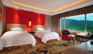 2 camas en una habitación de hotel con una pared roja en Grand Metropark Hotel Nanjing, en Nanjing
