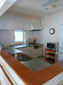 a kitchen with a sink and a counter top at ゲストハウス ikoi in Kyōgoku