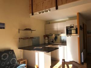 a kitchen with white cabinets and a black counter top at Appartement Corrençon-en-Vercors, 3 pièces, 8 personnes - FR-1-515-116 in Corrençon-en-Vercors