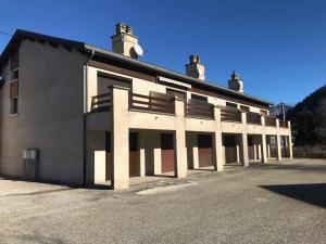 um grande edifício branco sentado ao lado de uma rua em Appartement 3 pièces + mezzanine, 6-8 pers., centre de Corrençon-en-Vercors, proche ski et golf - FR-1-515-116 em Corrençon-en-Vercors