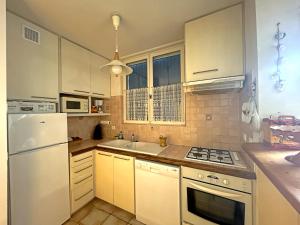 eine Küche mit weißen Geräten und einem weißen Kühlschrank in der Unterkunft Appartement Saintes-Maries-de-la-Mer, 3 pièces, 6 personnes - FR-1-475-125 in Saintes-Maries-de-la-Mer