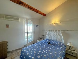 ein Schlafzimmer mit einem blauen Bett und einem Fenster in der Unterkunft Appartement Saintes-Maries-de-la-Mer, 3 pièces, 6 personnes - FR-1-475-125 in Saintes-Maries-de-la-Mer