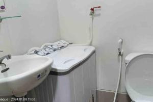 een witte badkamer met een wastafel en een toilet bij Doc's Place 5@ Spring Residences in Manilla