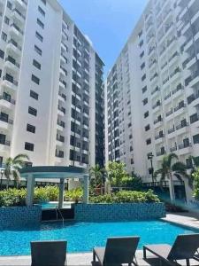 dois grandes edifícios de apartamentos com uma piscina em frente em Doc's Place 5@ Spring Residences em Manila