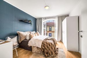 a bedroom with a bed and a blue wall at 3 Bedroom with a perfect location in Trondheim in Trondheim