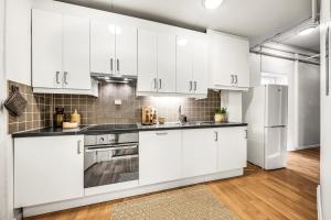 een keuken met witte kasten en een koelkast bij 3 Bedroom with a perfect location in Trondheim in Trondheim