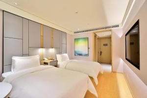 Un pat sau paturi într-o cameră la Ji Hotel Hangzhou Qianjiang Shijicheng