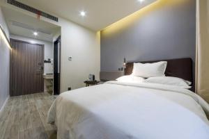 Un pat sau paturi într-o cameră la Hi Inn Shanghai Bei Waitan Shuangyang Road
