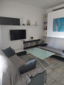 sala de estar con sofá y mesa de cristal en Apartamento en planta baja con vistar al mar, en Conil de la Frontera