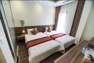 a bedroom with a large bed and a window at Hạ Long Legend Hotel in Ha Long