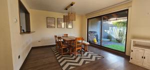 普孔的住宿－Bella casa en Costa Pucón，一间位于地毯上的带桌椅的用餐室