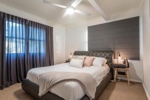 een slaapkamer met een groot bed en een plafondventilator bij Spacious 3-Bed with Amazing Views in Norman Park in Brisbane