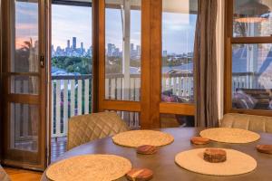 een tafel met strohoedjes op het balkon bij Spacious 3-Bed with Amazing Views in Norman Park in Brisbane