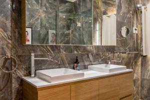 een badkamer met 2 wastafels en een spiegel bij Spacious 3-Bed with Amazing Views in Norman Park in Brisbane