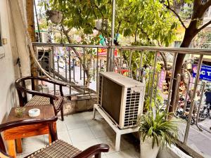 a television sitting on a balcony with a table and chairs at Central entire house in Hanoi beer street in Hanoi