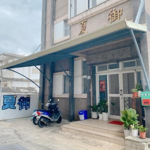 un scooter estacionado frente a un edificio en 綠島夏御 微熱海岸, en Isla Verde