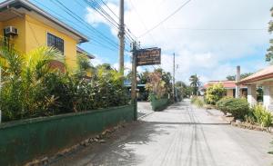 eine leere Straße mit einem Schild an der Seite eines Gebäudes in der Unterkunft Lauriens Hotel Tagaytay in Tagaytay