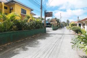 eine leere Straße vor einem gelben Gebäude in der Unterkunft Lauriens Hotel Tagaytay in Tagaytay