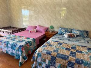 1 dormitorio con 2 camas y mesa con mesita de noche en Chambres bord de mer - raiatea en Uturoa
