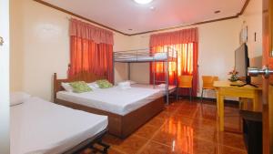 a bedroom with two bunk beds and a television at Lauriens Hotel Tagaytay in Tagaytay
