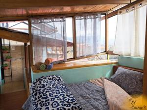 a bedroom with a bed in a room with windows at Minidepa hermosa vista - H. El Casero in Cajamarca