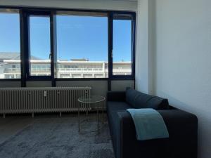 a living room with a couch and a table and windows at Simplex Apartments Am Marktplatz in Karlsruhe