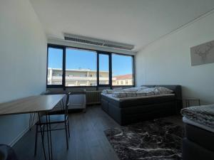 ein Wohnzimmer mit einem Bett, einem Tisch und einem Fenster in der Unterkunft Simplex Apartments Am Marktplatz in Karlsruhe