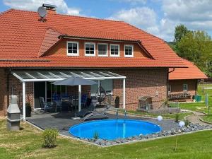 a house with a swimming pool in front of it at Holiday apartment Stephanie Ahlborn in Schönhagen