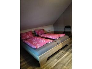 uma cama com almofadas cor-de-rosa em cima em Holiday apartment Stephanie Ahlborn em Schönhagen
