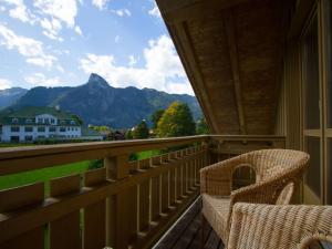 a balcony with two chairs and a view of a mountain at Lovely apartment in Oberammergau in Oberammergau