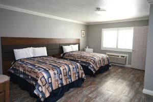 a hotel room with two beds and a window at Hollywood Stars Inn in Los Angeles