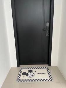 una alfombra Mickey delante de una puerta en Ipoh cove 米奇黑白家庭, en Ipoh