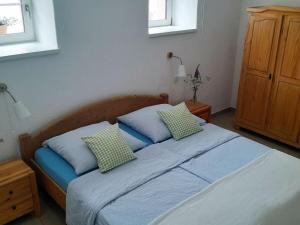 Schlafzimmer mit einem Bett mit blauer Bettwäsche und Kissen in der Unterkunft Charming apartment in Mandelbachtal in Wittersheim