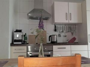 eine Küche mit einem Tisch und einer Vase mit Blumen in der Unterkunft Charming apartment in Mandelbachtal in Wittersheim