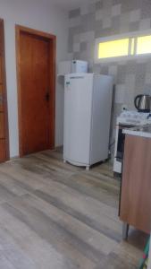 uma cozinha com um frigorífico branco e uma porta em Casa confortável! em Uruguaiana
