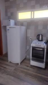 eine Küche mit einem weißen Kühlschrank und einem Herd in der Unterkunft Casa confortável! in Uruguaiana